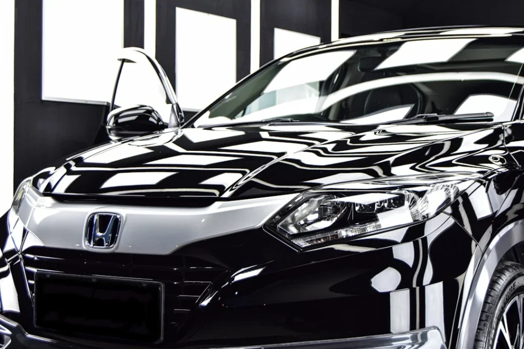 Proses merawat cat mobil warna hitam menggunakan kain microfiber berkualitas untuk menghindari baret halus.