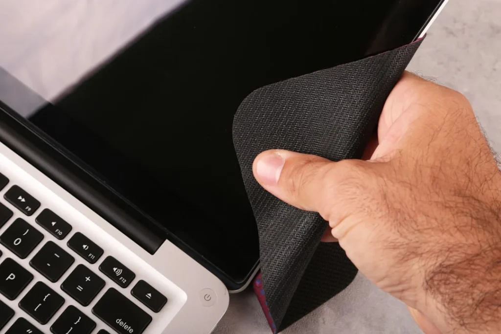 Ilustrasi cara membersihkan layar laptop menggunakan kain mikrofiber yang lembut
